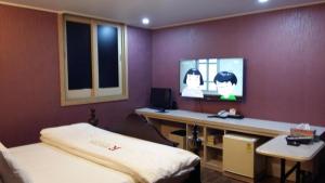 a bedroom with a bed and a tv on a wall at Residence R Hotel in Daegu