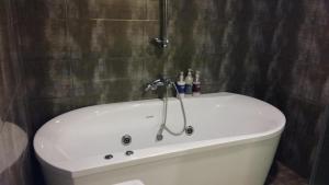 Residence R Hotel في دايغو: حوض استحمام أبيض في الحمام