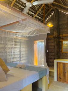 Windy Waves Kite Beach & Nature Resort في كالبيتيا: غرفة نوم مع سرير مظلة في غرفة