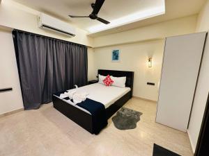 Schlafzimmer mit einem Bett mit einem schwarzen Kopfteil in der Unterkunft 1BR Service apartment in BKC by Florastays in Mumbai