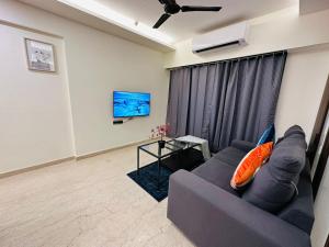 1BR Service apartment in BKC by Florastays في مومباي: غرفة معيشة مع أريكة وتلفزيون