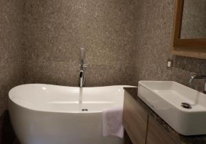 La salle de bains est pourvue d'un lavabo blanc et d'un miroir. dans l'établissement The Margaux Hotel Yogyakarta, à Yogyakarta