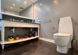 uma casa de banho com WC e uma prateleira com plantas em Suite Coco CarIbe em Porlamar