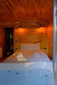 een bed in een houten kamer met een bad bij Sapanca Grandwooden in Sakarya