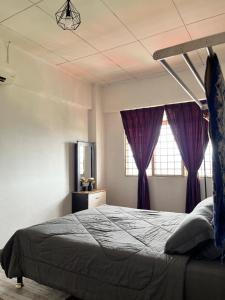 1 dormitorio con 1 cama grande y cortinas moradas en Homestay Vista3A at Vista Seri Putra en Kajang