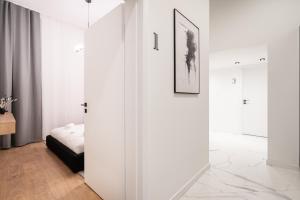 um quarto branco com uma cama e uma porta de correr em E56 Queen's Boutique Apartment,best Location by BQA em Budapeste