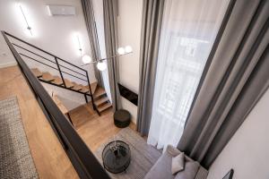 a living room with a staircase and a window at E56 Queen's Boutique Apartment,best Location by BQA in Budapest