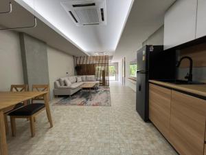 cocina y sala de estar con sofá y mesa en The Green Golf Apartments en Ban Thung Thong