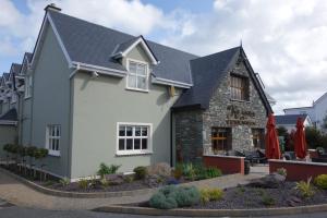 una casa blanca con techo negro en Keanes of Curraheen, en Tralee