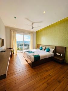 a bedroom with a large bed and a large window at VAGA NAKSHATHRA SUITES in Vagamon