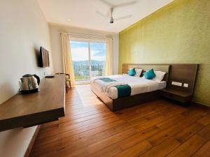 a bedroom with a bed and a large window at VAGA NAKSHATHRA SUITES in Vagamon