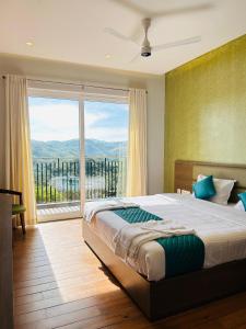 a bedroom with a large bed and a large window at VAGA NAKSHATHRA SUITES in Vagamon