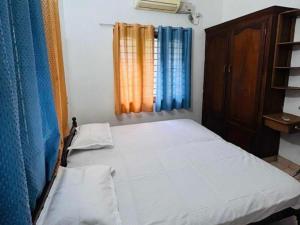a small bedroom with a bed and a window at OYO GoodInn Apartment in Elūr