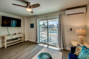 a living room with a couch and a flat screen tv at Sand Dollar 1 in Fort Myers Beach
