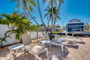 a group of chairs and tables on a patio with palm trees at Sand Dollar 1 in Fort Myers Beach