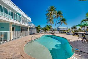 a swimming pool in front of a building with palm trees at Sand Dollar 1 in Fort Myers Beach