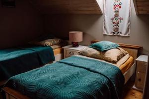 a bedroom with two beds and a table with a lamp at Chata drewniana Stefanówka in Ślemień +173 photos