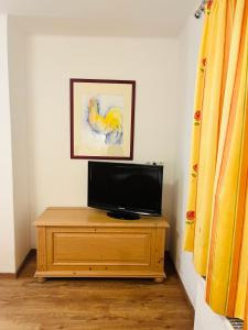 a television sitting on top of a wooden dresser at Ferienwohnung Ingrid Hörbiger in Mittersill