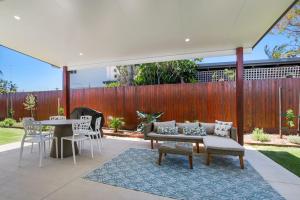 a patio with a couch and a table and chairs at Browning Boulevard 9, Battery Hill in Caloundra