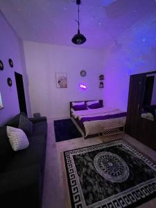 a purple room with a bed and a couch at Remas's Studio in Corniche Abu Dhabi in Abu Dhabi