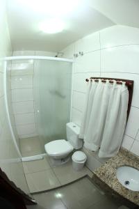 a bathroom with a toilet and a shower and a sink at Hotel Schneider in Treze Tílias
