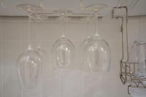 four glass wine glasses hanging from a wall at Soo Guest House in Seoul