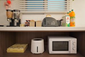a microwave oven sitting on a shelf in a kitchen at Soo Guest House in Seoul