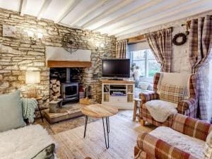 ein Wohnzimmer mit einer Steinmauer in der Unterkunft 2 Bed in Minchinhampton 72872 in Minchinhampton