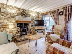a living room with a stone wall at 2 Bed in Minchinhampton 72872 in Minchinhampton
