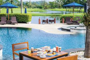 a table with food on it next to a pool at Homm Suites Laguna in Bang Tao Beach