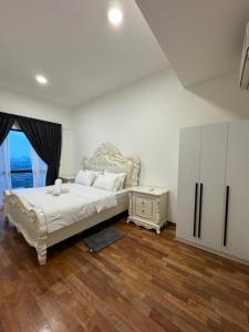 a bedroom with a white bed and a dresser and a window at Reizz Residence by Perkasa in Kuala Lumpur