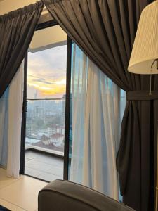 een kamer met een raam met een bank en een lamp bij Reizz Residence by Perkasa in Kuala Lumpur