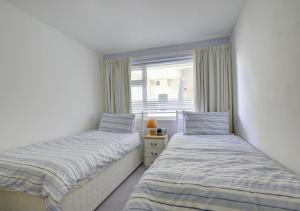 two beds in a room with a window at Sandy Reach ( Croft Court ) in Tenby