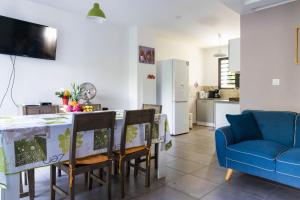 cocina con mesa y sillas y sofá azul en Appart Maïté 4, en La Saline-Les-Bains