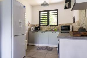 cocina con armarios blancos y nevera en Appart Maïté 4, en La Saline-Les-Bains