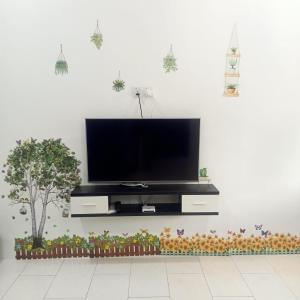a living room with a television on a wall at The 88 Homestay in Batu Pahat