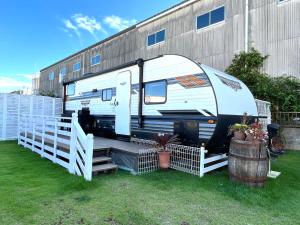 an rv parked in a yard next to a building at 九十九里 SURF SIDE DOGRUN HOUSE in Katakai