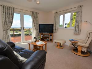 a living room with a couch and a tv at 1 bed in Bude SCADG in Poughill