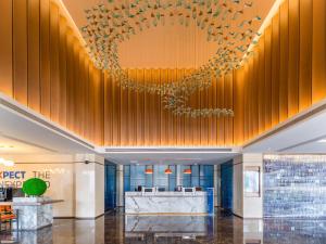 een lobby van een hotel met een kroonluchter bij Holiday Inn Express Yuhuan Wetland Park, an IHG Hotel in Yuhuan