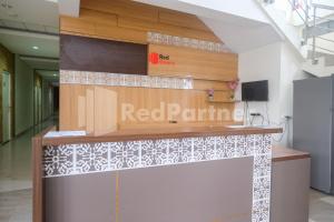 a reception desk in a building with a red paint sign at Garuda Guesthouse Yogyakarta RedPartner in Yogyakarta