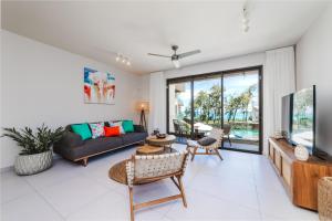 a living room with a couch and a tv at Brand new, Beachfront Ocean Terraces, Poste Lafayette-Apt-C4 in Poste Lafayette