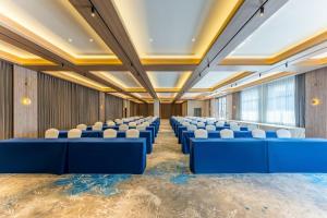 Holiday Inn Express Yuhuan Wetland Park by IHG في Yuhuan: قاعة المؤتمرات مع الطاولات الزرقاء والكراسي البيضاء +72 صورة