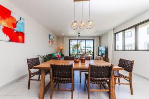 a dining room with a wooden table and chairs at Brand new, Beachfront Ocean Terraces, Poste Lafayette-Apt-C4 in Poste Lafayette