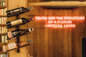 a group of wine bottles on a pole in a library at Secret Window Residency in Ban Kat Hao