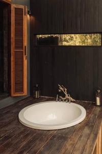 a bathroom with a white tub on a wooden floor at Secret Window Residency in Ban Kat Hao +19 photos