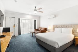 a hotel room with a bed and a desk at The International Motel in Apollo Bay