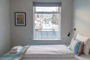 um quarto com uma cama em frente a uma janela em Hildibrand Apartment Hotel em Neskaupstaður