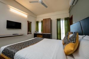a bedroom with a large bed and a flat screen tv at CJ GRANDE BUSINESS HOTEL in Ernakulam