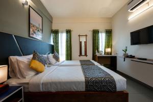 1 dormitorio con 1 cama grande y TV en CJ GRANDE BUSINESS HOTEL, en Ernakulam