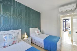 1 dormitorio con 2 camas y pared verde en Duplex Bahia Meloneras 47 by VillaGranCanaria en Meloneras